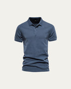 Polo de manga corta azul, diseño liso con cuello abotonado y dobladillo recto.